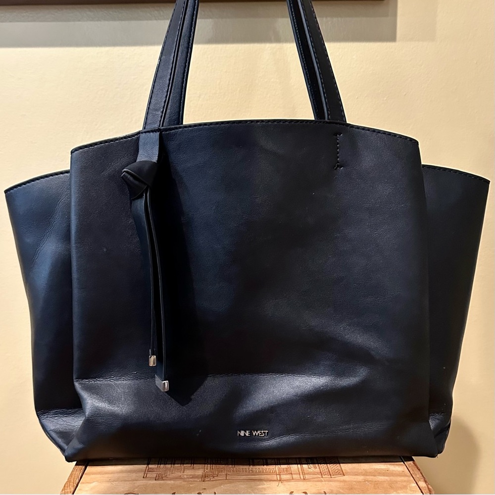 Black shoulder bag by Nine West with three large interior pockets for storage